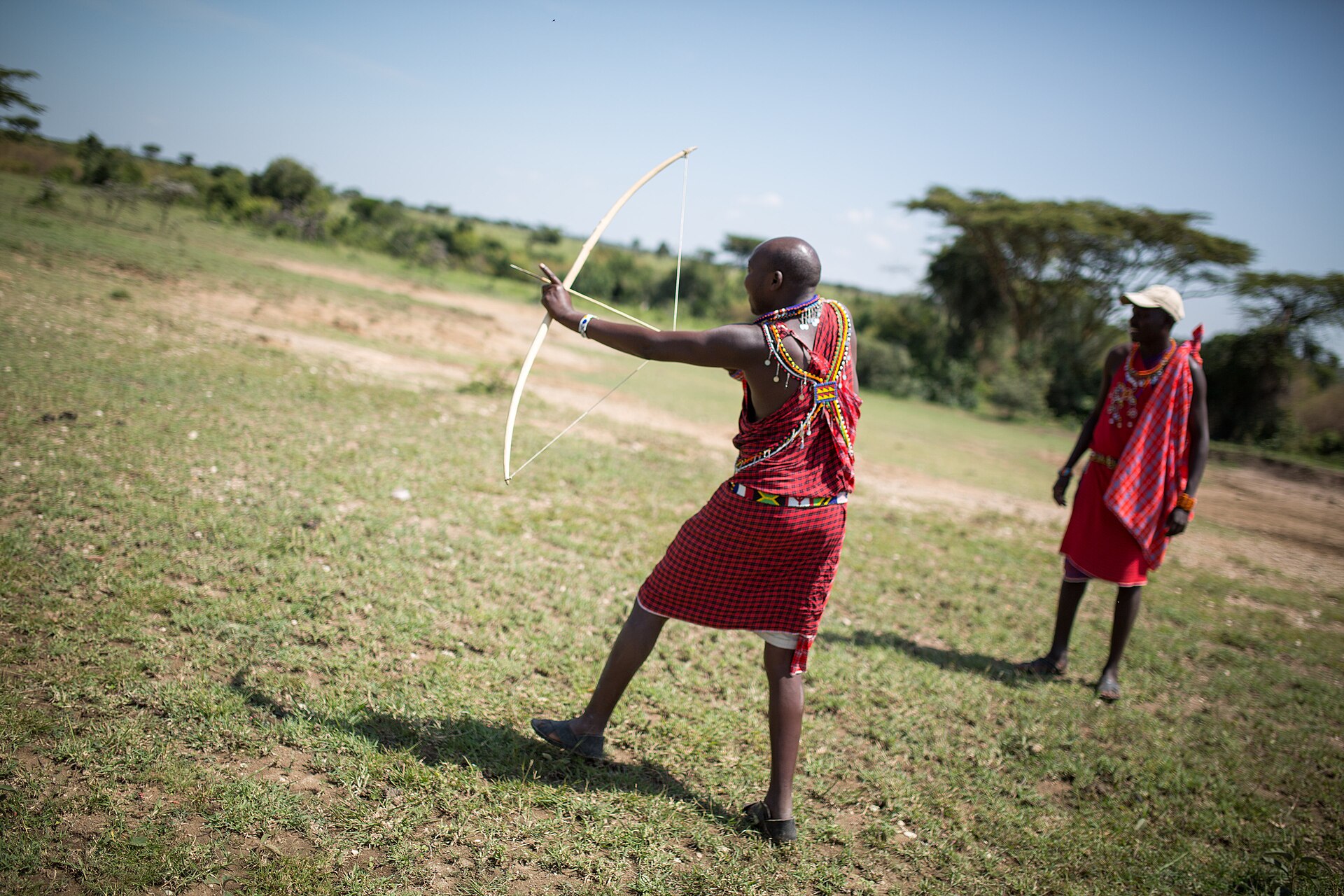 A Maasai guide leading visitors on a walking safari